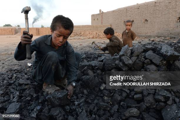 In this photograph taken on April 28 Afghan children work at a coal yard on the outskirts of Jalalabad.