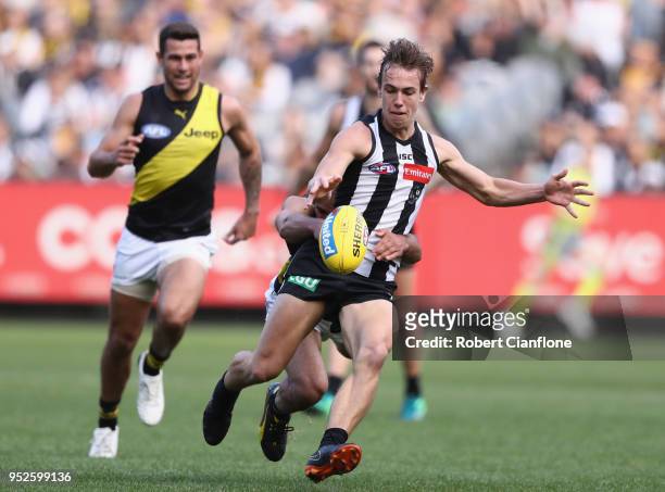James Aish of the Magpies is pressured by Bachar Houli of the Tigers during the AFL round six match between the Collingwood Magpies and Richmond...