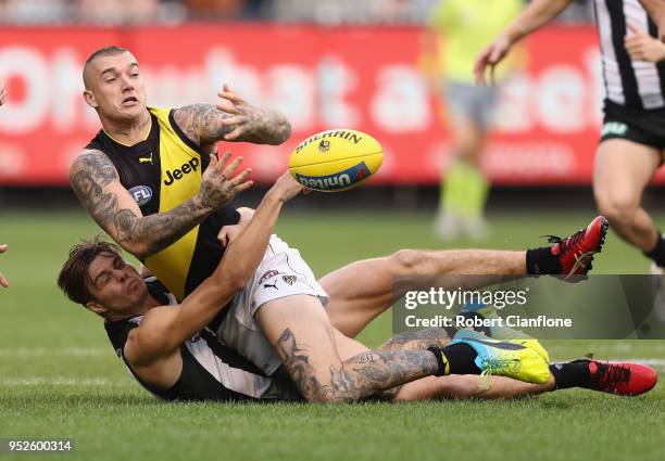 Dustin Martin of the Tigers is challenged by Josh Thomas of the Magpies during the AFL round six match between the Collingwood Magpies and Richmond...