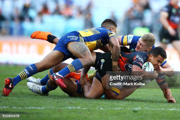 Esan Marsters of the Tigers is tackled during the round Eight NRL match between the Parramatta Eels and the Wests Tigers at ANZ Stadium on April 29,...