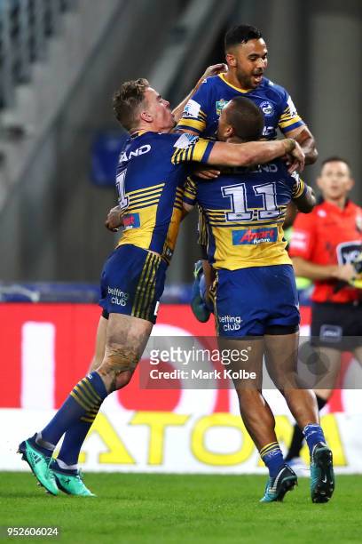 Manu Ma'u of the Eels celebrates with his team mates Clint Gutherson and Bevan French after scoring a try during the round Eight NRL match between...