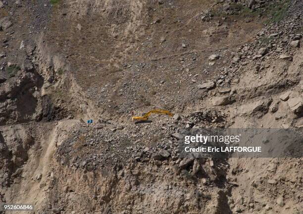 Yellow excavator working on amountain road, Badakhshan province, Darmadar, Afghanistan.