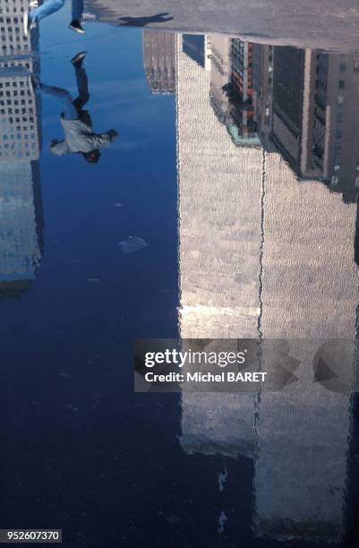 Reflet d'un homme sautant dans une flaque d'eau à New York City en janvier 2001.