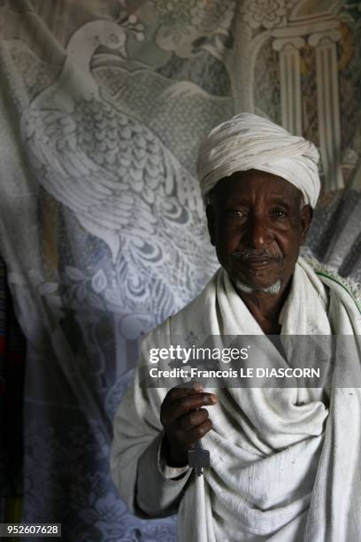 Coptic priest showing an old crucifix from his monastery . On Lake Tana on April 8, 2009 in Bahir Dar, Ethiopia.