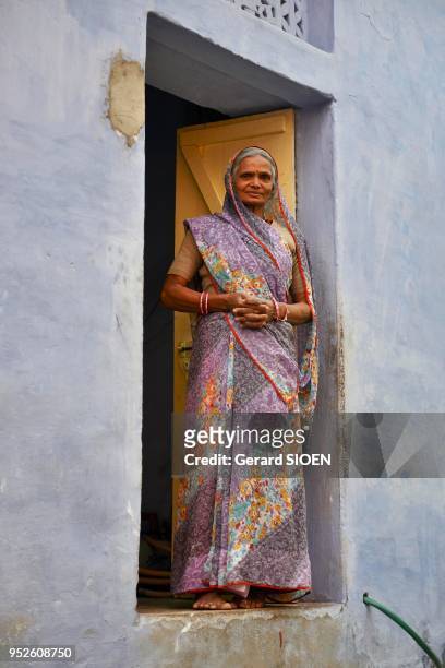Inde, Rajasthan, region du Mewar, village de Bundi, femme sur le pas de sa porte//India, Rajasthan, Mewar region, Bundi village, woman on the door...