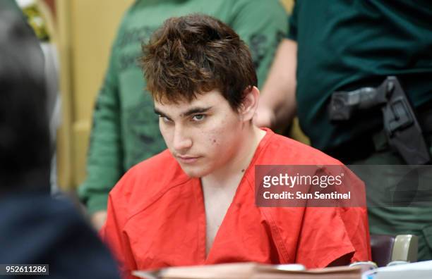 Florida school shooting suspect Nikolas Cruz quickly glances up at the prosecutors while in court before Circuit Judge Elizabeth Scherer for a...