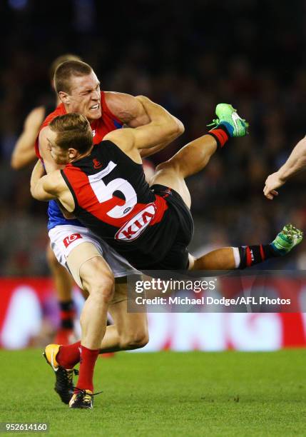 Devon Smith of Essendon tackles Tom McDonald of the Demons during the round 6 AFL match between the Essendon Bombers and Melbourne Demons at Etihad...