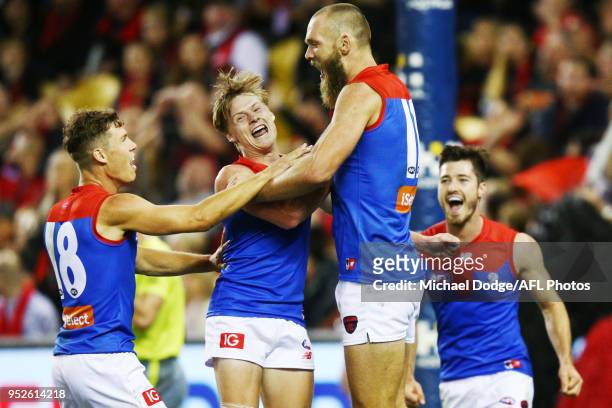 Max Gawn of the Demons celebrates a goal with Jake Melksham and Charlie Spargo during the round 6 AFL match between the Essendon Bombers and...