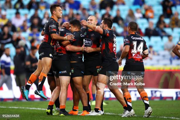 Matt Eisenhuth of the Tigers celebrates with his team mates after scoring a try during the round Eight NRL match between the Parramatta Eels and the...