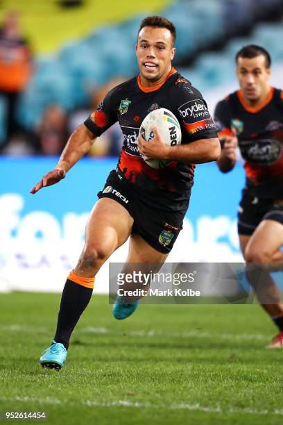 Luke Brooks of the Tigers runs the ball during the round Eight NRL match between the Parramatta Eels and the Wests Tigers at ANZ Stadium on April 29,...