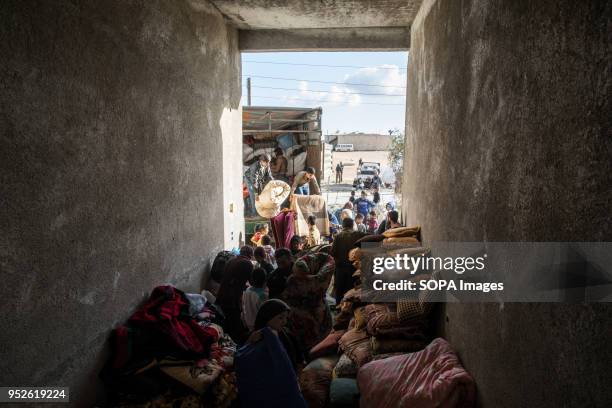 Thousands of blankets donated from Kobane Canton in Northeastern Syria are unloaded near Tall Rifat for distribution to refugees displaced from the...