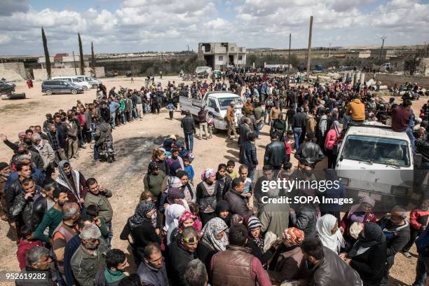 Thousands of people displaced from Afrin line up to receive bread in the village of Fafin, South of Tall Rafat. An estimated 400,000 refugees fleeing...