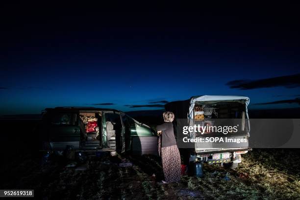 Woman stands outside her familys cars, now their home, in a field in the town of Ahras. An estimated 400,000 refugees fleeing the two-month-old...