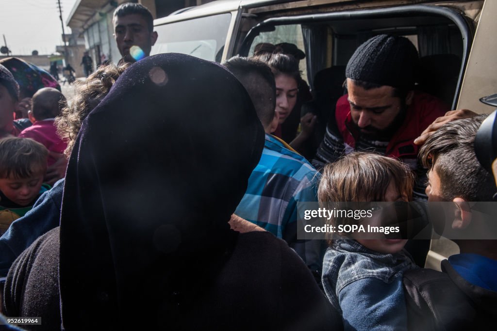 A child cries out as her mother waits to receive aid from...