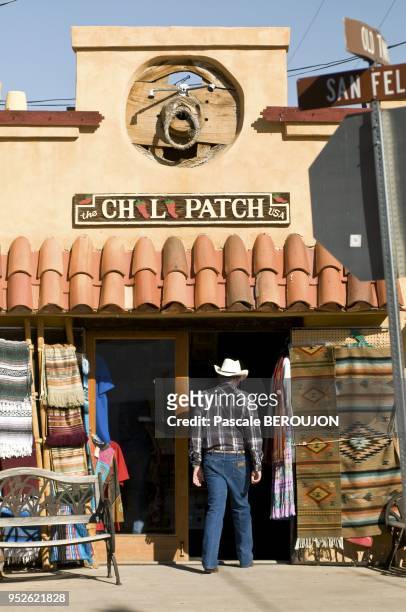 Homme agé, vetu du jean wrangler de la chemise a carreaux et du chapeau de cowboy, entre dans une boutique de la vieille ville d'Albuquerque, le 1er...