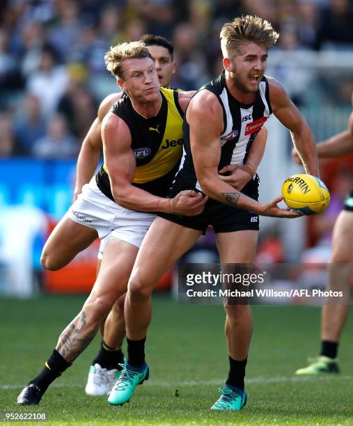 Sam Murray of the Magpies is tackled by Josh Caddy of the Tigers during the 2018 AFL round six match between the Collingwood Magpies and the Richmond...