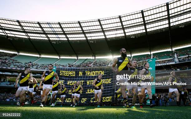 The Tigers run through their banner during the 2018 AFL round six match between the Collingwood Magpies and the Richmond Tigers at the Melbourne...