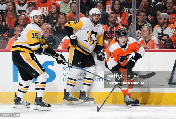 Nolan Patrick of the Philadelphia Flyers completes a pass against Brian Dumoulin and Riley Sheahan of the Pittsburgh Penguins in Game Six of the...