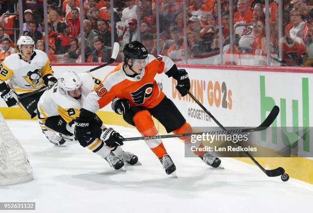 Nolan Patrick of the Philadelphia Flyers skates the puck behind the net against Brian Dumoulin of the Pittsburgh Penguins in Game Six of the Eastern...