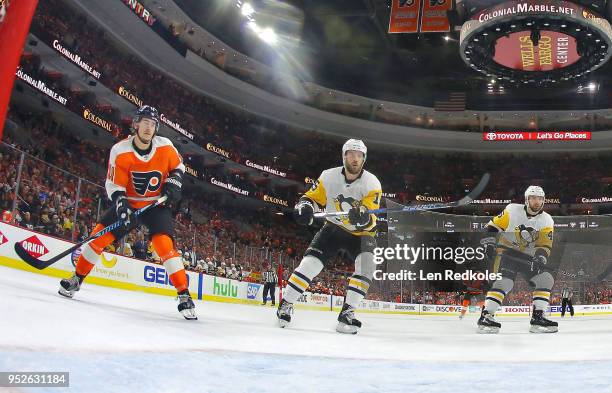 Travis Konecny of the Philadelphia Flyers skates toward the crease against Riley Sheahan and Zach Aston-Reese of the Pittsburgh Penguins in Game Six...