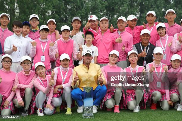 Alexander Bjork of Sweden holds the trophy with volunteers celebrates after winning the 2018 Volvo China Open at Topwin Golf and Country Club on...