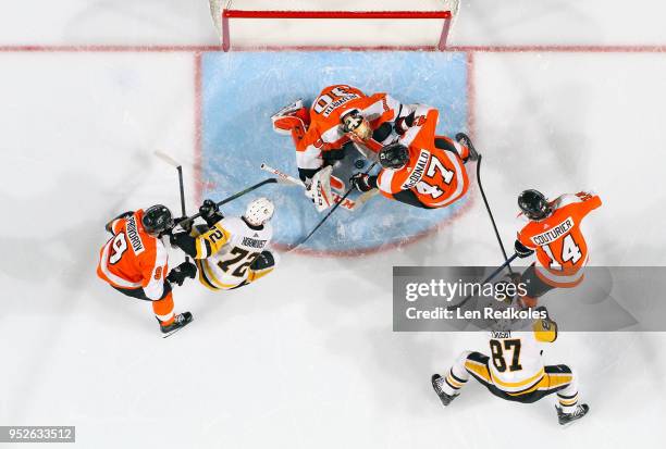 Sean Couturier, Ivan Provorov, Michal Neuvirth and Andrew MacDonald of the Philadelphia Flyers battle to cover the loose puck in the crease against...