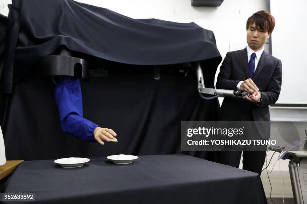 Newly developed robot hand GP-Arm , developed by Keio University's assistant professor Takahiro Nozaki, grips roll a bread and a potato chip during a...