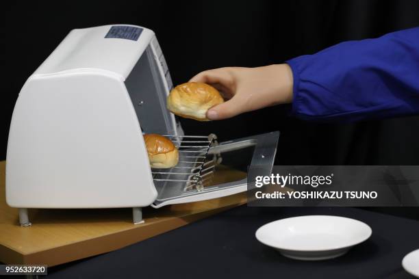 Newly developed robot hand GP-Arm , developed by Keio University's assistant professor Takahiro Nozaki, grips roll a bread and a potato chip during a...