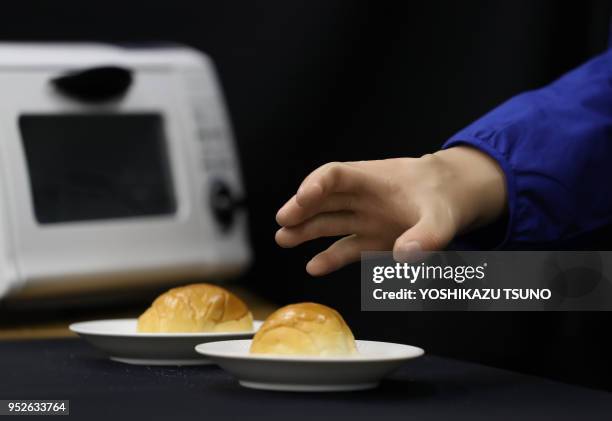 Newly developed robot hand GP-Arm , developed by Keio University's assistant professor Takahiro Nozaki, grips roll a bread and a potato chip during a...