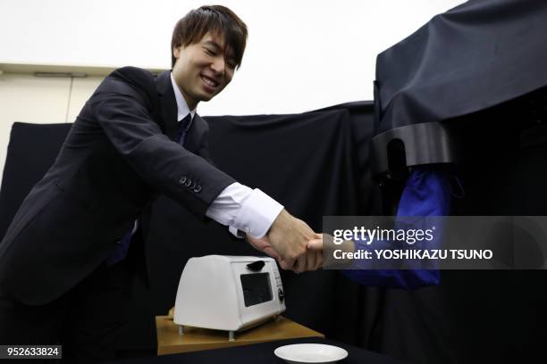 Newly developed robot hand GP-Arm , developed by Keio University's assistant professor Takahiro Nozaki, grips roll a bread and a potato chip during a...