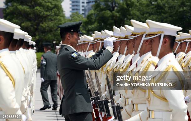 Un officier japonais aligne la casquette d'un garde lors d'un passage en revue de la Garde d'honneur le 4 aout 2016, Tokyo, Japon.