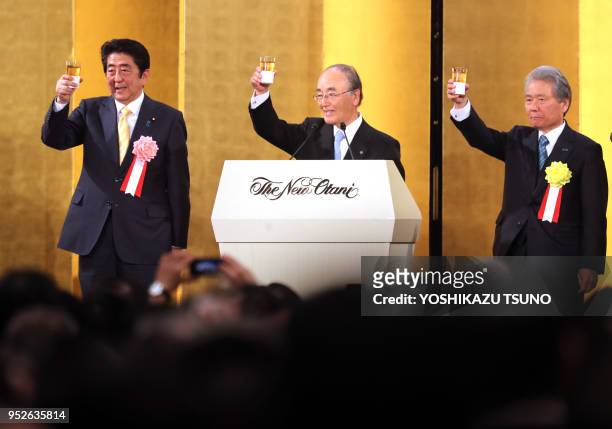 Japanese Prime Minister Shinzo Abe toasts with Japanese business group leaders Akio Mimura and Sadayuki Sakakibara during business leaders' New Year...