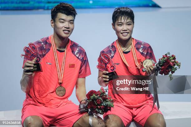 Wang Yulyu and Huang Dongping of China pose with gold medals on the podium after winning the mixed doubles final match against Tontowi Ahmad and...