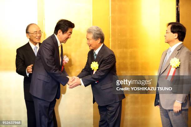 Japanese Prime Minister Shinzo Abe is greeted by Japanese business group leaders Akio Mimura and Sadayuki Sakakibara for a business leaders' New Year...