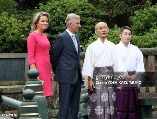 Belgian King Philippe and Queen Mathilde listen to a Shinto priest as they visit the Nezu shrine in Tokyo on October 10, 2016. Belgian royal couple...