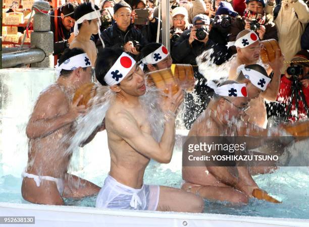 Des croyants du shintoïsme se versent de l'eau froide sur eux-mêmes pour purifier leurs corps et leurs âmes lors du festival de Daikoku au temple de...