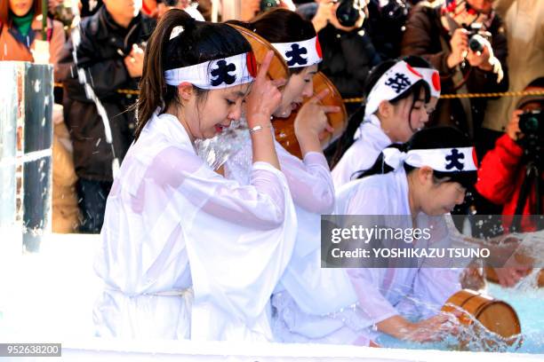 Des femmes croyantes du shintoïsme se versent de l'eau froide sur elles-mêmes pour purifier leurs corps et et leurs âmes lors du festival de Daikoku...