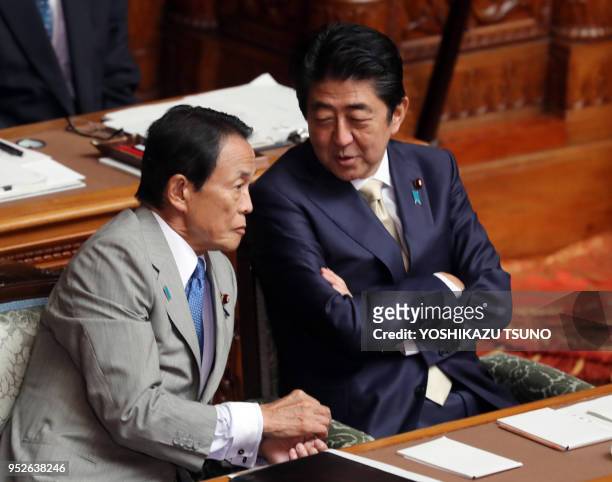Le premier ministre japonais Shinzo Abe discutant avec son ministre des finances Taro Aso lors d'une session extraordinaire de la Diète le 28...
