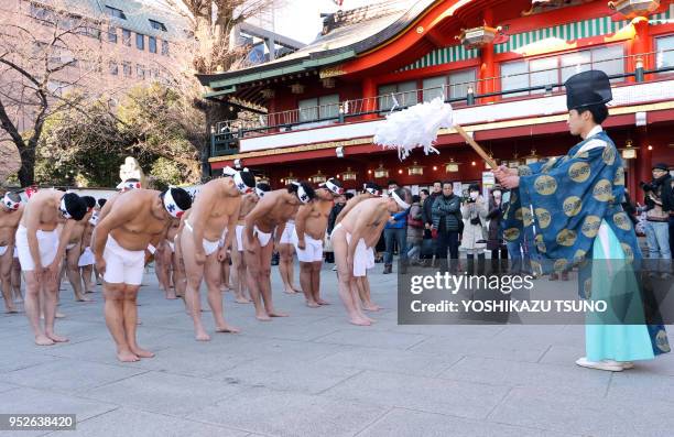 Des croyants du shintoïsme s'inclinent devant un prêtre lors de la cérémonie de purification de leurs corps et et de leurs âmes lors du festival de...