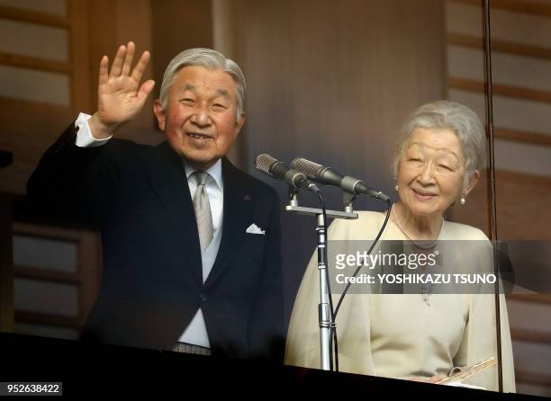 Japanese Emperor Akihito , accompanied by Empress Michiko waves to well-wishers gathered for the annual New Year's greetings at the Imperial Palace...