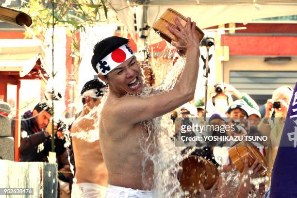 Des croyants du shintoïsme se versent de l'eau froide sur eux-mêmes pour purifier leurs corps et leurs âmes lors du festival de Daikoku au temple de...
