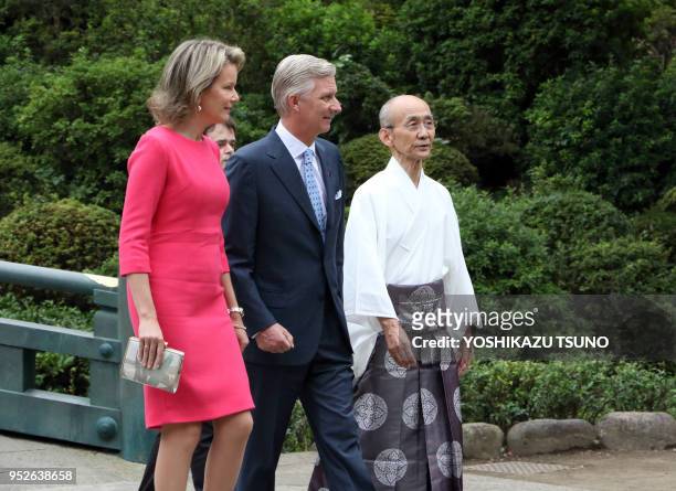 Belgian King Philippe and Queen Mathilde listen to a Shinto priest as they visit the Nezu shrine in Tokyo on October 10, 2016. Belgian royal couple...