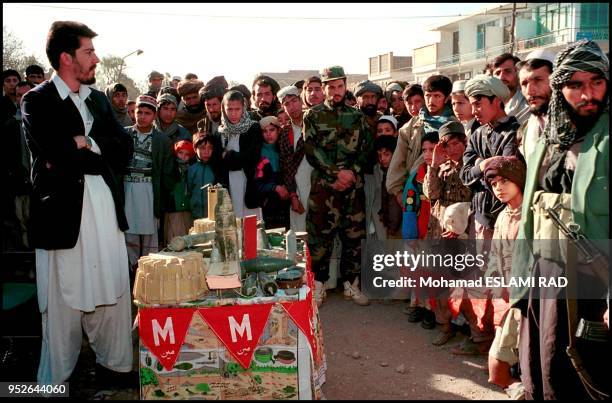 Herat;specialize group of deminers shows, on city square, different mines and explains how people should react.