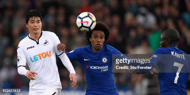 Swansea player Ki Sung-Yeung challenges Willian of Chelsea as Kante looks on during the Premier League match between Swansea City and Chelsea at...