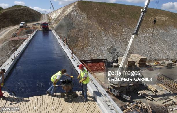 Mise en oeuvre de l'asphalte pour l'etancheite du tablier d'un pont, passage superieur, lors de la construction de l'autoroute A89 entre Bordeaux et...