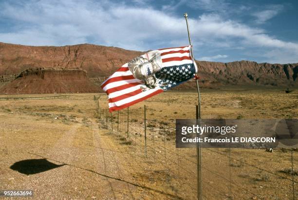 American flag with image of an American Indian on it turned upside down on the flagpole in the middle of the desert, near Page, 2007 in Arizona.