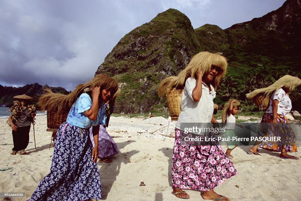 Ivatan Rituals An Ivatan family walks up the beach of Sabtang island. They are going ...