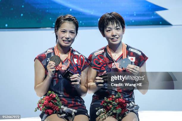 Yuki Fukushima and Sayaka Hirota of Japan pose gold medals on the podium after winning the women's doubles final match against Misaki Matsutomo and...