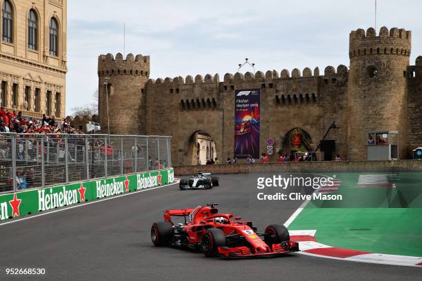 Sebastian Vettel of Germany driving the Scuderia Ferrari SF71H leads Lewis Hamilton of Great Britain driving the Mercedes AMG Petronas F1 Team...