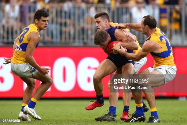 Darcy Tucker of the Dockers gets tackled by Elliot Yeo and Shannon Hurn of the Eagles during the Round 6 AFL match between the Fremantle Dockers and...